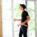 A,Handsome,Young,Man,Installing,Double,Sliding,Patio,Door,In